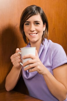 Portrait of a young woman holding a coffee cup