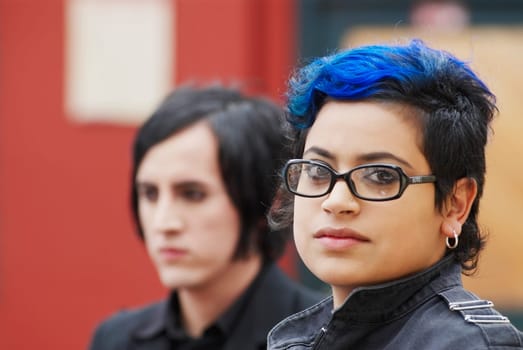 Portrait of a young woman with a young man behind her