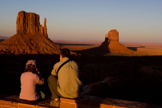 Tourists looking at rock formations in a valley, Monument Valley Tribal Park, Arizona_Utah, USA