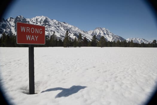 Sign post on a snow covered field with mountains in the background, Grand Teton National Park, Wyoming, USA