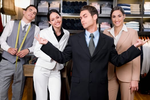 Portrait of a businessman with two saleswomen and a tailor in a store
