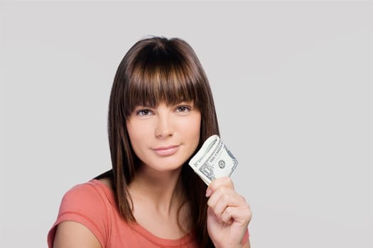 Portrait of a young woman holding one dollar bills and thinking