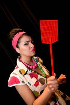 Portrait of a young woman holding a fly swatter