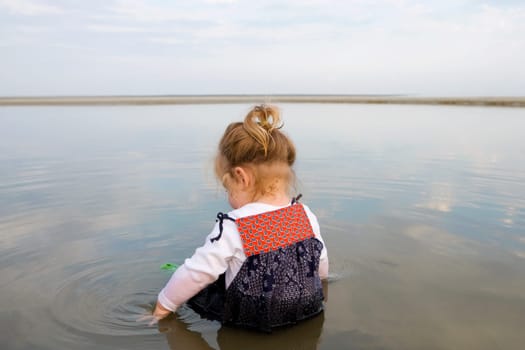 Rear view of a baby girl sitting in water