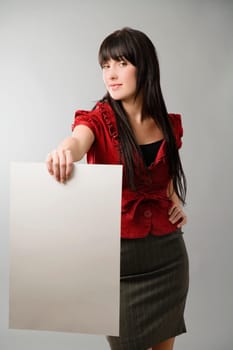 Portrait of a young woman holding a sheet of paper and smiling