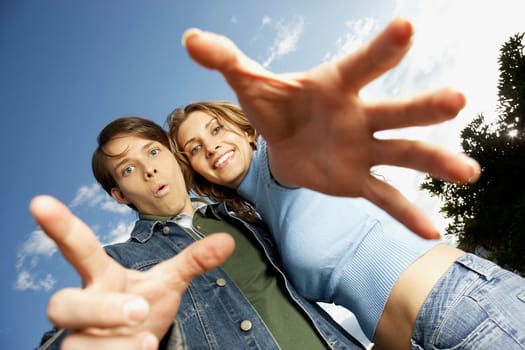 Low angle view of a young couple with their arms outstretched