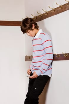 Teenage boy text messaging on a mobile phone