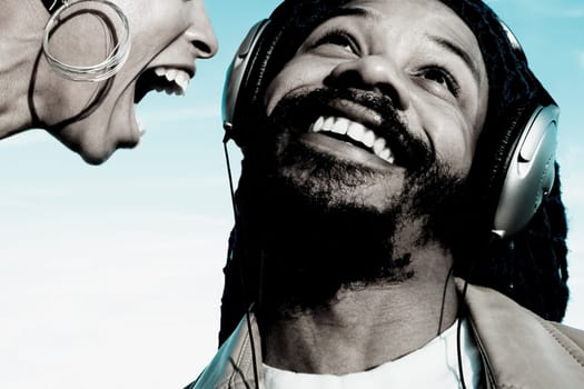 Mid adult man listening to music and a young woman shouting in front of him