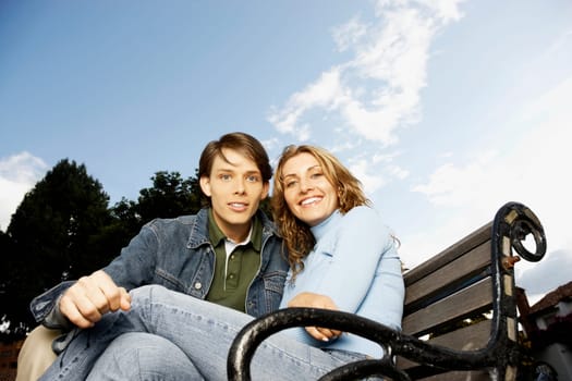 Portrait of a young couple sitting on a bench