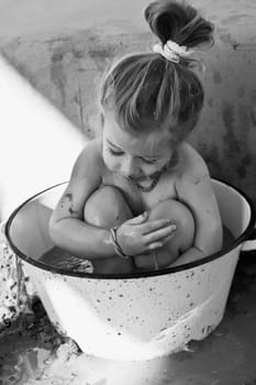 Baby girl sitting in a bathtub