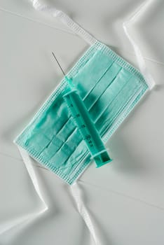 High angle view of a syringe on a surgical mask