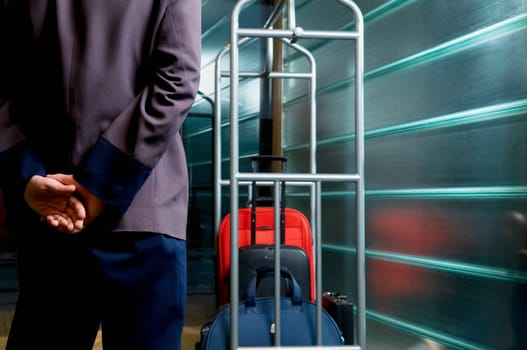 Rear view of a waiter standing near a luggage rack