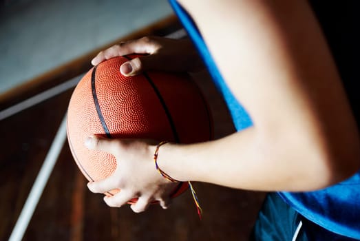 Mid section view of a person holding a basketball