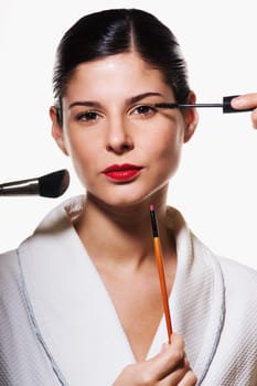 Portrait of a young woman applying make_up