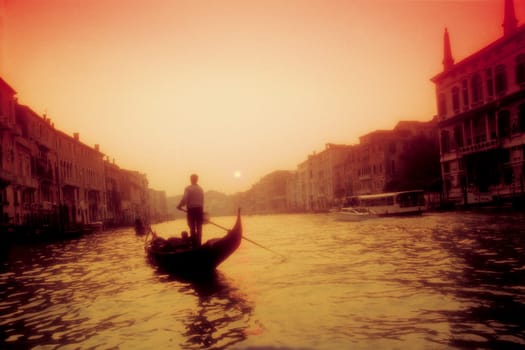 Gondolier rowing a gondola in a canal, Grand Canal, Venice, Veneto, Italy