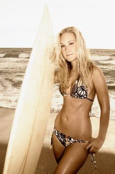 Portrait of a young woman with a surfboard standing on the beach