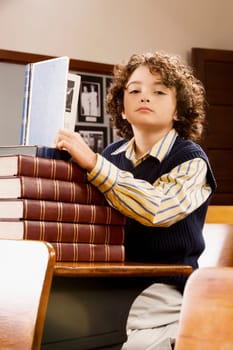 Schoolboy holding a book in a classroom