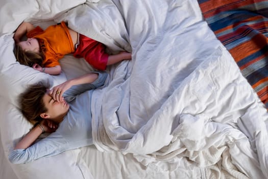 High angle view of a mid adult woman sleeping with her daughter