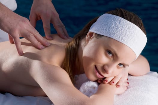 Portrait of a young woman getting back massage from a massage therapist
