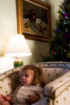 Baby girl sitting in an armchair