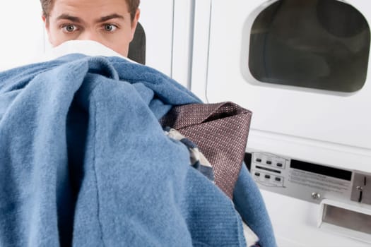 Man carrying clothes in a laundromat