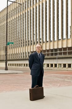 Businessman standing with hands behind back