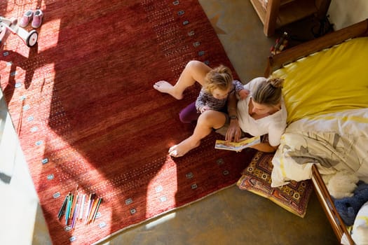 High angle view of a mid adult woman teaching her daughter