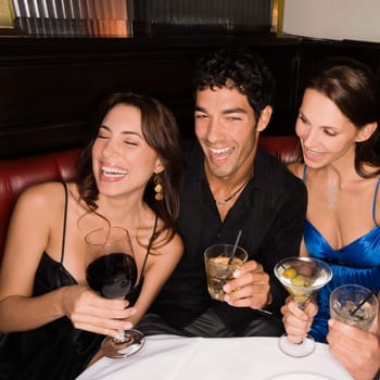 Three friends sitting at a table and smiling