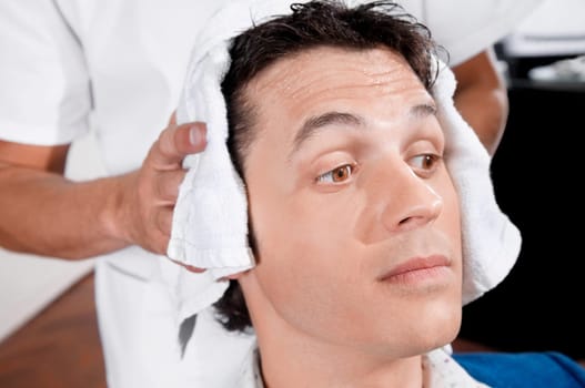 Barber rubbing a towel on a manŽs hair