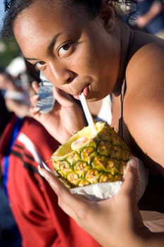 Portrait of a girl holding a mobile phone and drinking pineapple juice