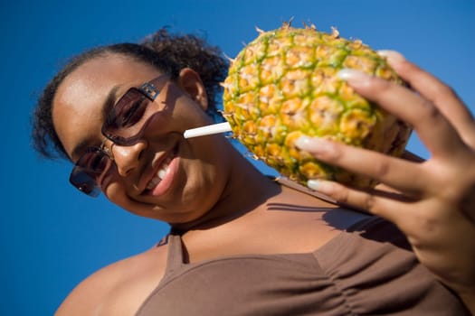 Low angle view of a teenage girl holding a pineapple cocktail, Chicago, Illinois