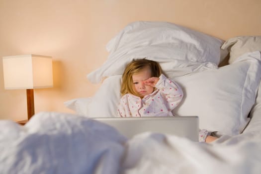Baby girl reclining on the bed