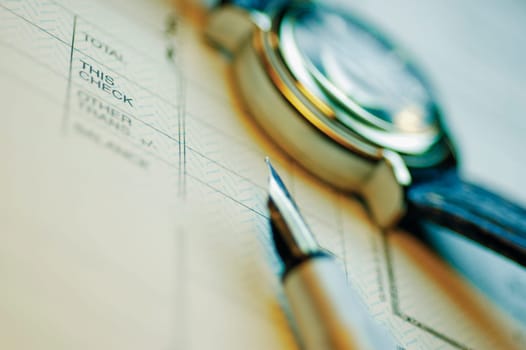 Close_up of a pen and a wristwatch on a file