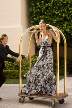 Couple playing with a trolley in front of a hotel, Biltmore Hotel, Coral Gables, Florida, USA
