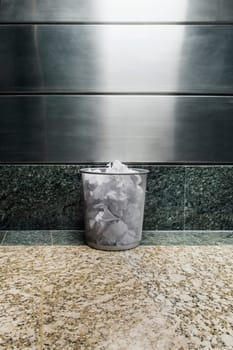Garbage bin in front of a wall