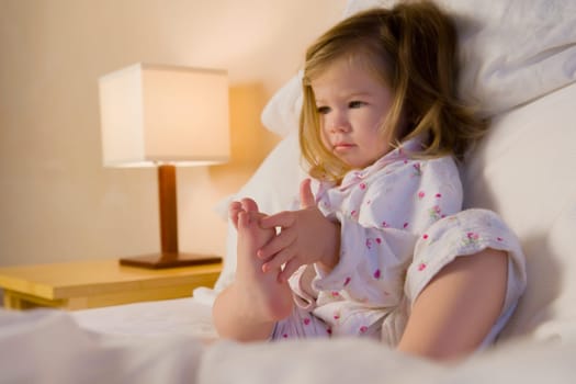 Baby girl sitting on the bed