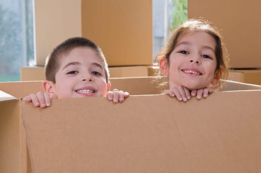 Portrait of two children smiling in a cardboard box