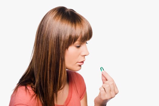Close_up of a young woman taking a pill