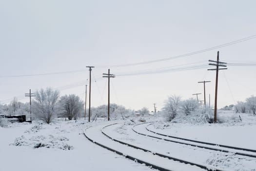Railroad tracks passing through a snow covered landscape