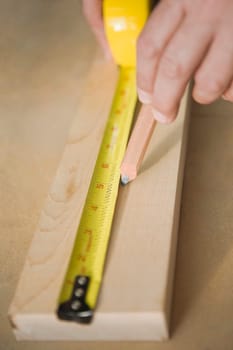 Close_up of a personŽs hands measuring a wooden plank