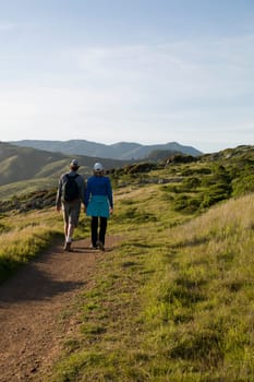 Rear view of two hikers walking on a footpath