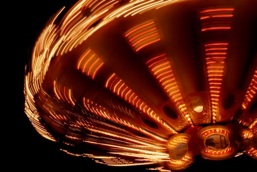 Close_up of a carousel spinning at night