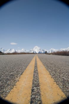 Dividing lines on a road with mountains in the background, Grand Teton National Park, Wyoming, USA