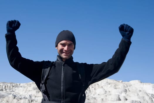 Mid adult man standing with his arms raised