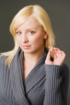 Portrait of a young woman holding her earring