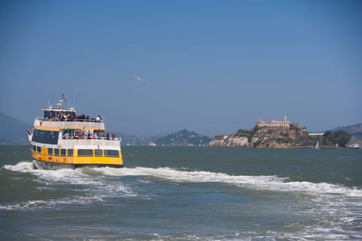 Ferry in the sea with a prison in the background, Alcatraz Prison, Alcatraz Island, San Francisco Bay, San Francisco, California, USA