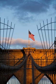 Low angle view of an American flag fluttering on a bridge, Brooklyn Bridge, New York City, New York State, USA