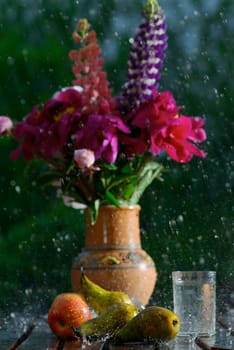 Close_up of a flower pot with fruits in rain