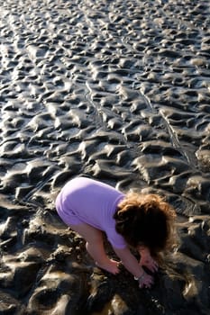 High angle view of a baby playing with mud