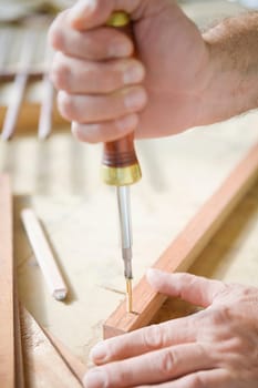 Close_up of a personŽs hand tightening a screw with a screwdriver